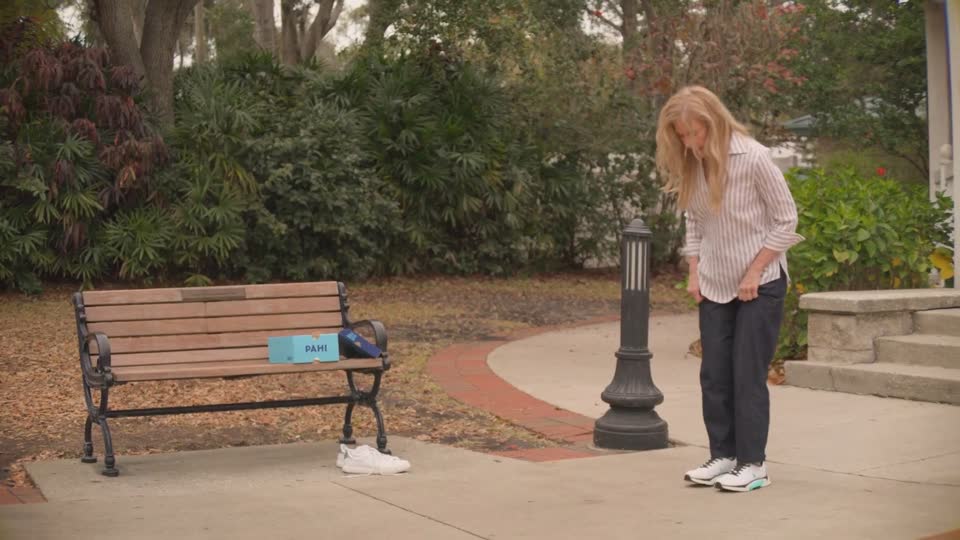 Woman at a park bench, PAHI box beside her